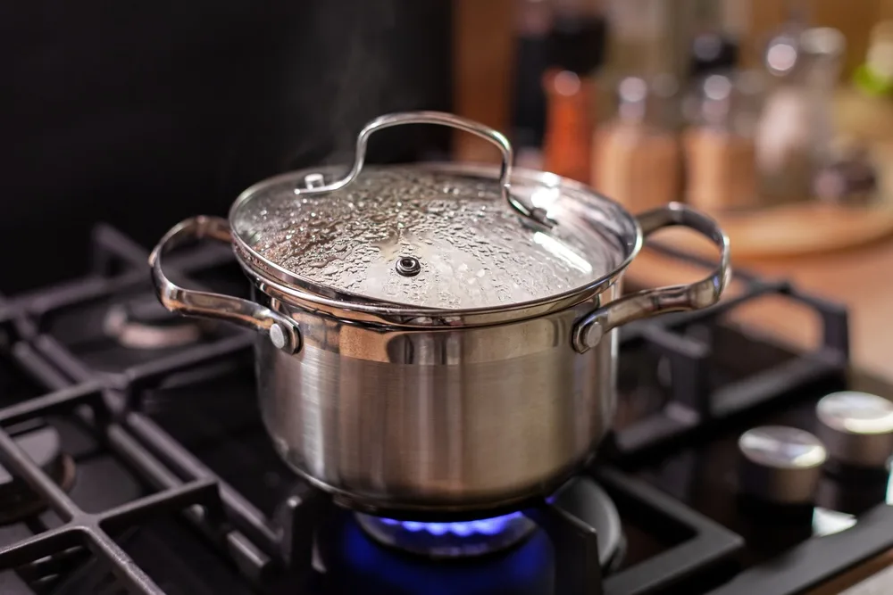 Kartoffeln kochen: Mit oder ohne Deckel? Ein Topf mit Deckel auf einem Gasherd